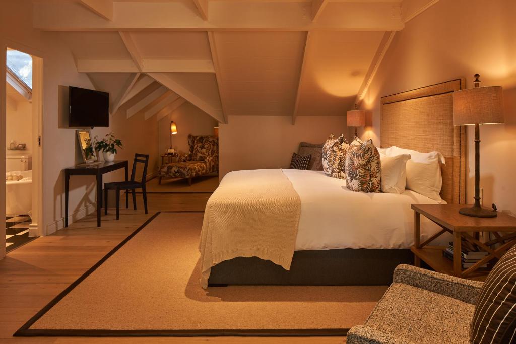 Elegant hotel bedroom suite with comfortable bed and seating area at Leeu House.